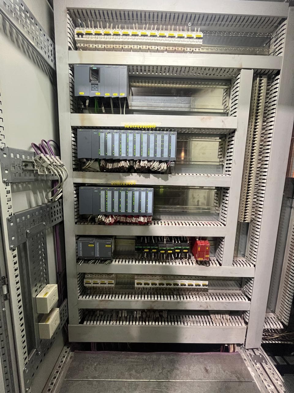 Tablero de automatización con PLC Siemens y módulos de entradas y salidas.
